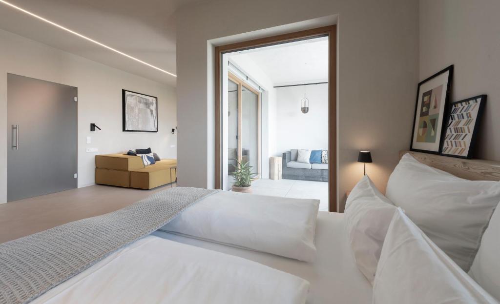 een slaapkamer met een wit bed en een glazen schuifdeur bij La Loggia Georg in Pianizza di Sopra