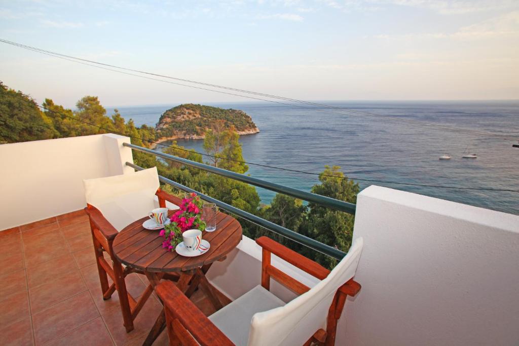 a balcony with a table and chairs and the ocean at Kalithea Studios in Stafylos