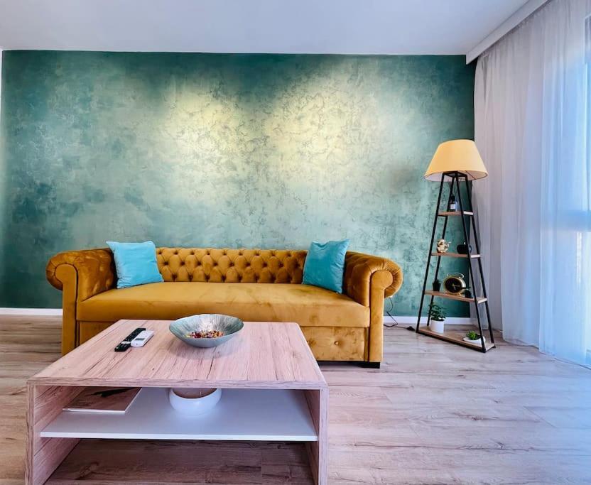 a living room with a yellow couch and a table at Apartament Vipii’s Residence in Arad