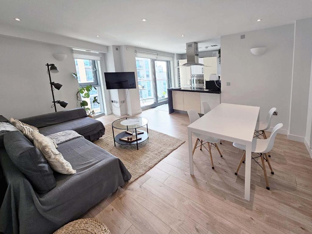 uma sala de estar com um sofá e uma mesa em Beautiful 2 bedroom flat in Battersea em Londres