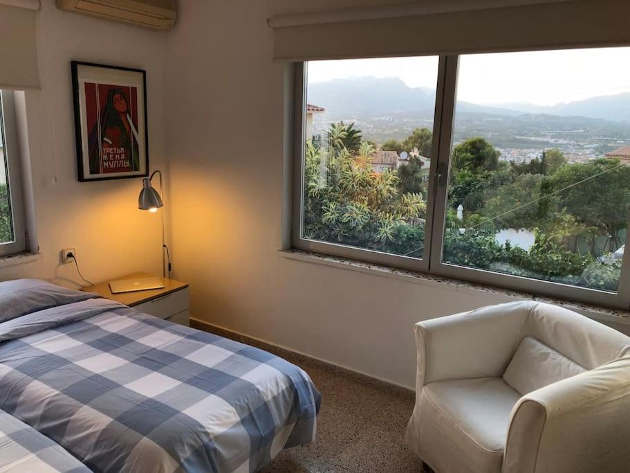 - une chambre avec un lit, une chaise et une fenêtre dans l'établissement Villa in Albir, à L'Alfàs del Pi
