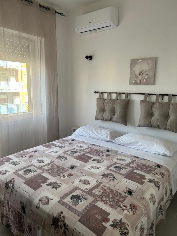 Un dormitorio con una cama con una colcha encima en Piccola Flo rooms, en Cagliari