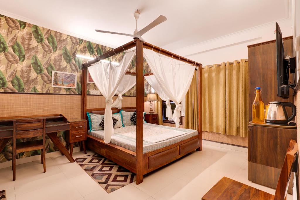 1 dormitorio con cama con dosel y escritorio en House of Comfort Noida, en Noida