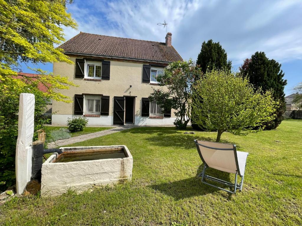 une chaise assise dans la cour d'une maison dans l'établissement Gîte le Calyaden, à Athis