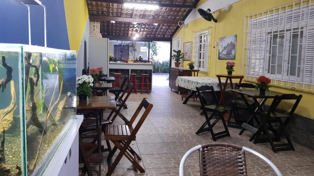 ein Restaurant mit Tischen und Stühlen und einem Aquarium in der Unterkunft Hostel Caminho da Praia in Arraial do Cabo