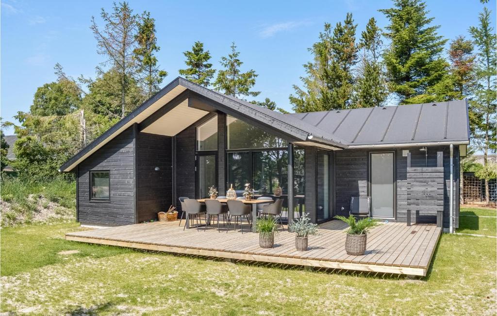 a black modular home with a wooden deck at Nice Home In Hadsund With Kitchen in Hadsund