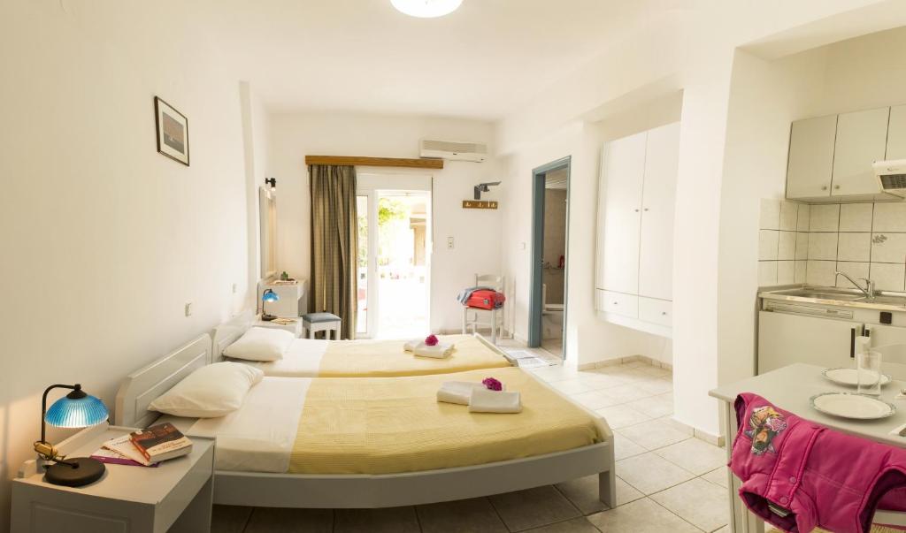 a hotel room with two beds and a kitchen at Edgewater Studios in Kissamos