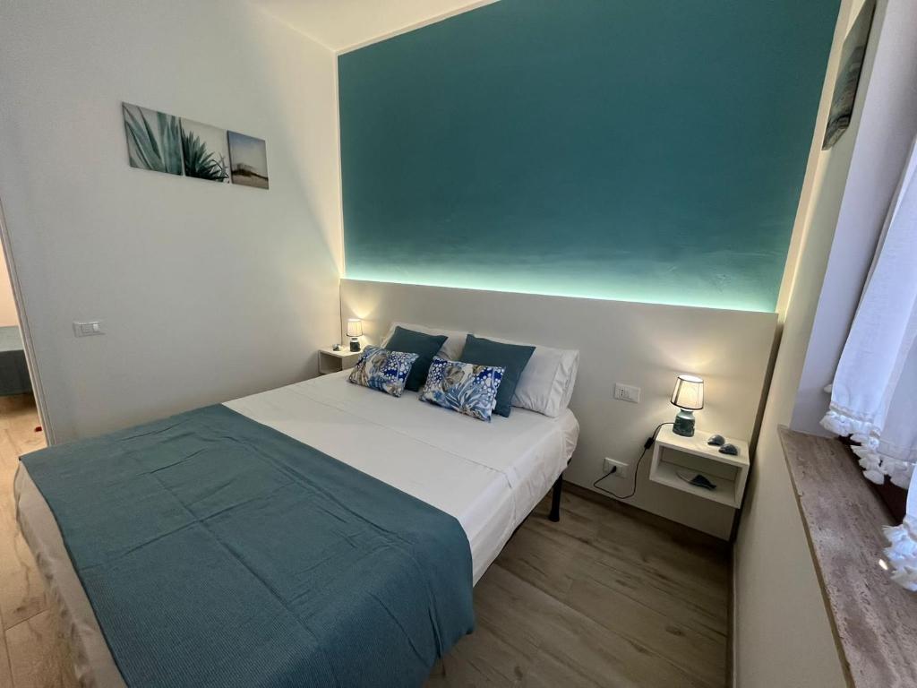 Habitación pequeña con cama y pared azul en Ca San Vito Lo Capo Villa Maria, en San Vito lo Capo