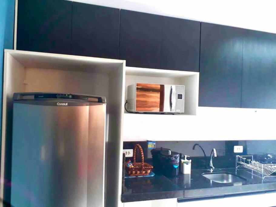 una cucina con frigorifero in acciaio inossidabile e lavandino di Melhor custo benefício: elegância e conforto. a Maringá