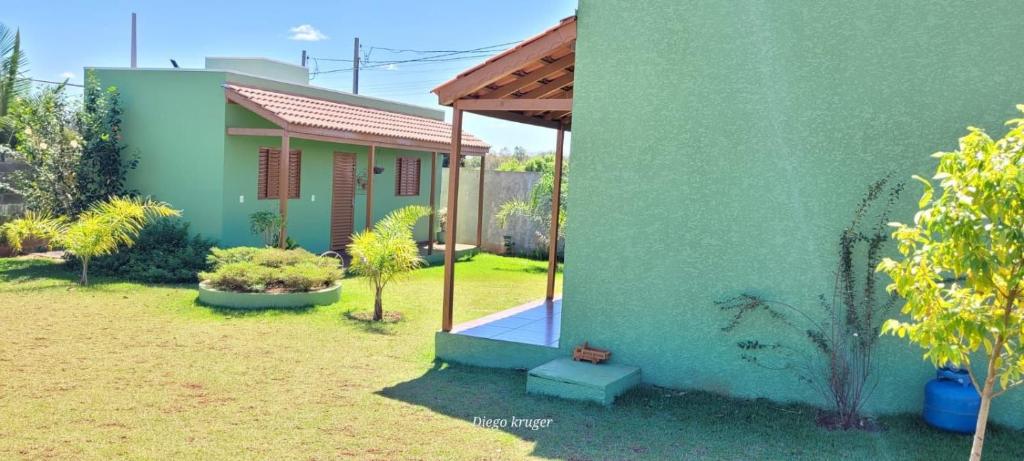 ein kleines Haus mit einer grünen Wand in der Unterkunft Casa perto das Cataratas Seu lar para quatro in Foz do Iguaçu