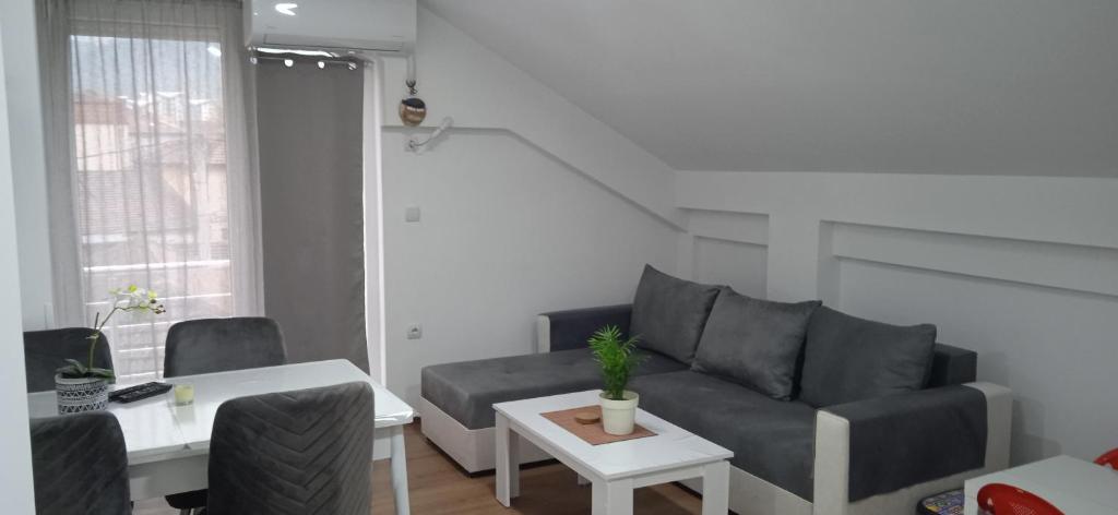 ein Wohnzimmer mit einem Sofa und einem Tisch in der Unterkunft Apartment, sweet home in the town-center. in Bitola