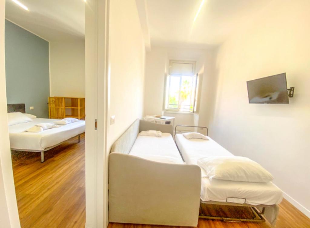 um quarto com duas camas e uma janela em Lexie Suites em Roma