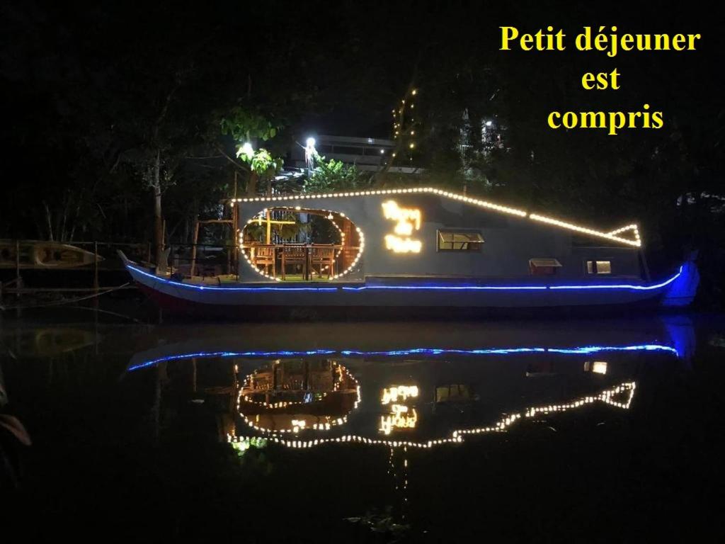 un bateau avec des lumières sur l'eau la nuit dans l'établissement Homestay Phong de Pêche, à Ấp Tân Bình (1)
