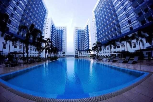 ein großes Schwimmbad in einer Stadt mit hohen Gebäuden in der Unterkunft Sea Residence Finest in Manila