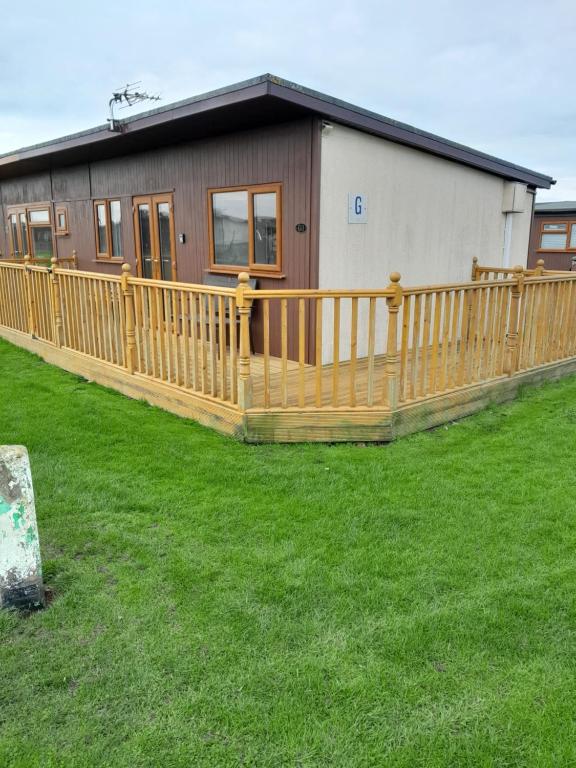 a wooden deck in front of a house at Immaculate 2-Bed Apartment in Mablethorpe in Mablethorpe