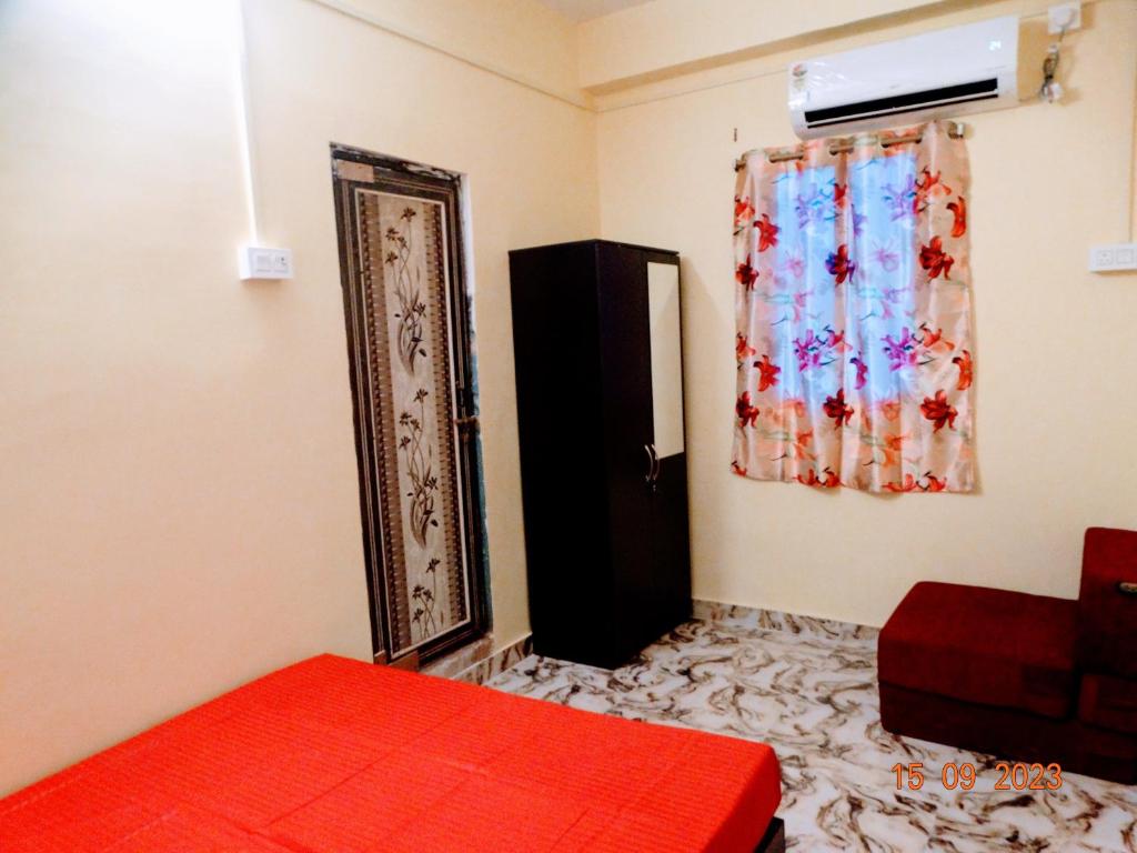 sypialnia z czerwonym łóżkiem i oknem w obiekcie Hotel Shree Ram SIA Residency w mieście Gaja
