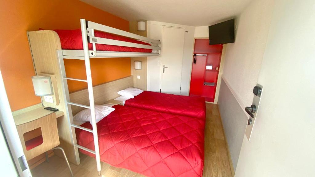 a small room with two bunk beds with red sheets at Premiere Classe Quimper in Quimper