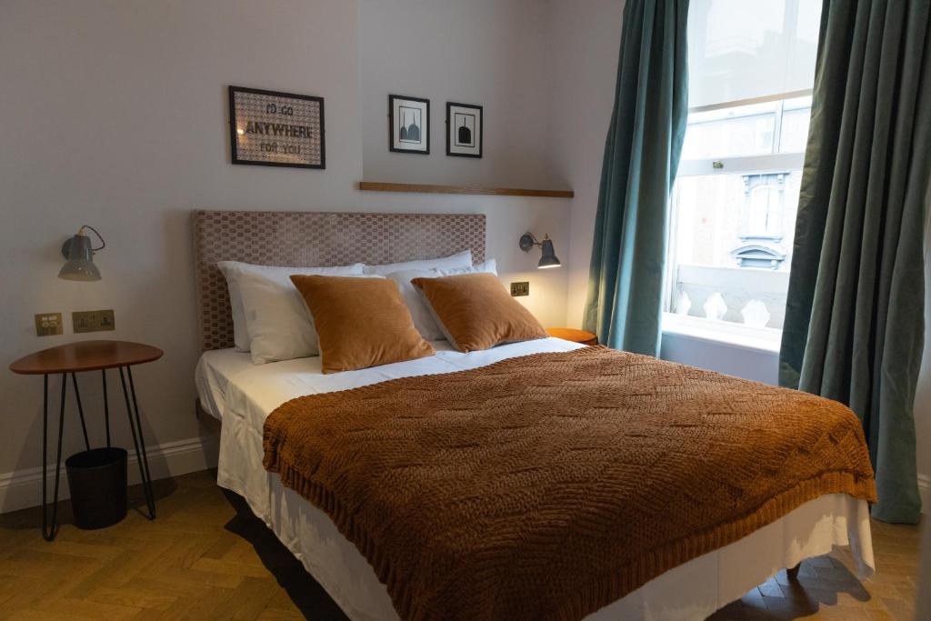 a bedroom with a large bed and a window at THE KNIGHT OF NOTTINGHILL in London