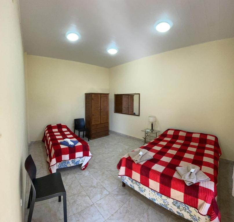 um quarto com duas camas e uma cadeira em Apartamento Río y Selva em Puerto Iguazú