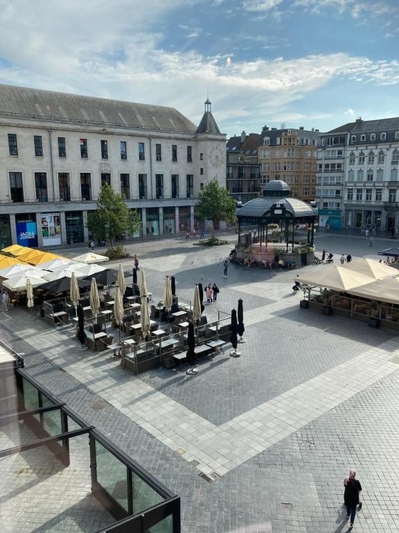 a courtyard with tables and umbrellas in a city at Appartement De Markt in Ostend