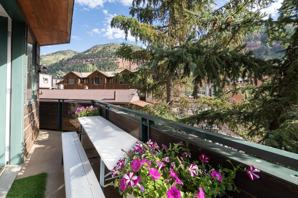 a bench on the balcony of a house with flowers at Ice House 317 condo in Telluride