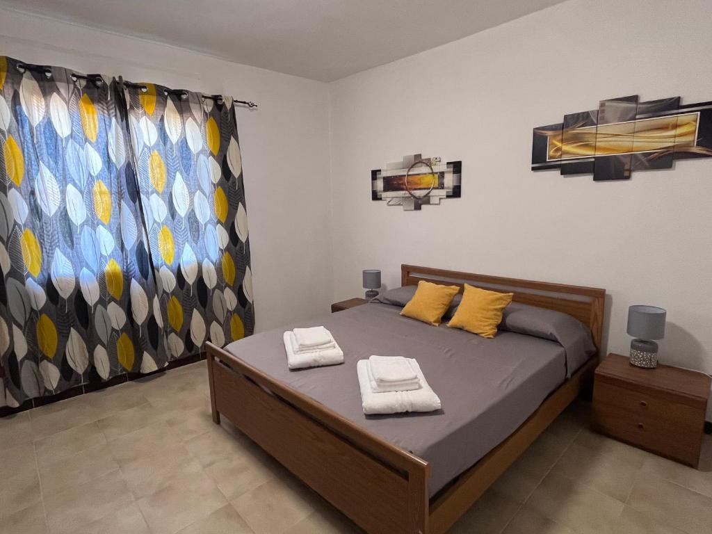 1 dormitorio con 1 cama y 2 toallas en Il Sole en Donigala Fenughedu