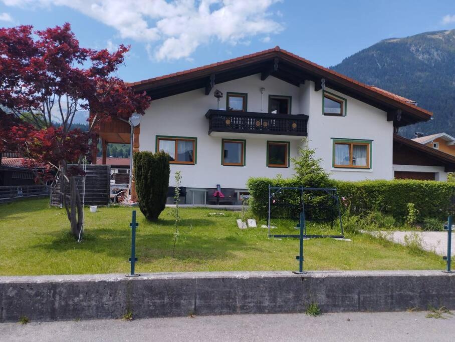 a white house with a fence in front of it at Ferienwohnung Patrycja in Weissenbach am Lech