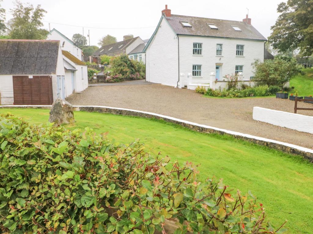 EglwyswrwにあるY Cartwsの白い家と白い柵のある庭