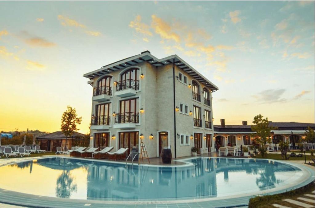una casa con una gran piscina frente a un edificio en Vinea Resort, en Durrës