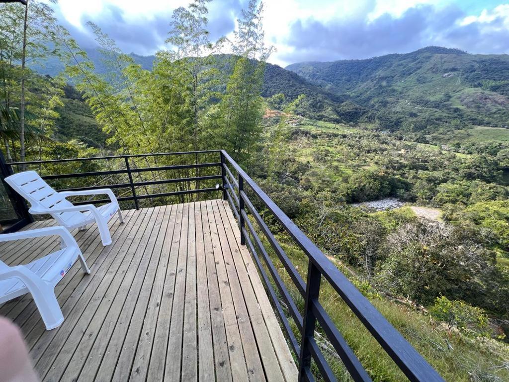 a deck with two white chairs and a view of a valley at El Templo del Agua in San Rafael