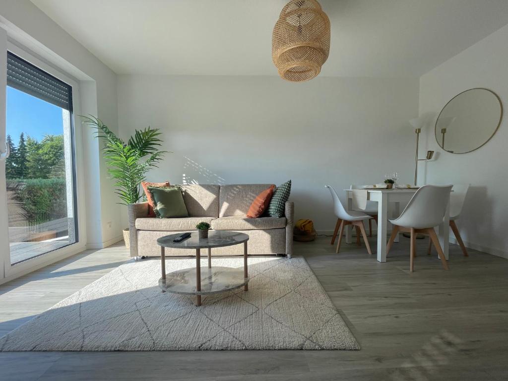 a living room with a couch and a table at Modernes und helles Mini-Haus in Peine in Peine