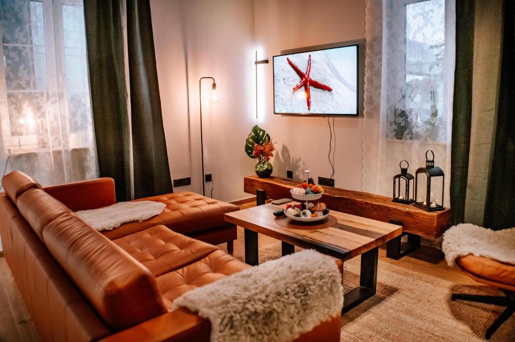 ein Wohnzimmer mit einem Sofa und einem Tisch in der Unterkunft Apartman Saturn in Osijek