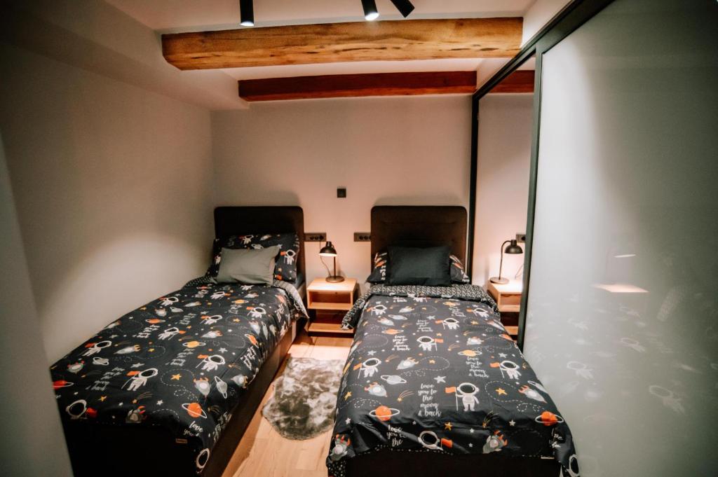 two beds in a small room with two beds sidx sidx sidx at Apartman Saturn in Osijek