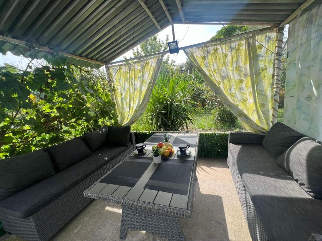un patio con un sofá negro y una mesa en Villa Julia en Nea Michaniona