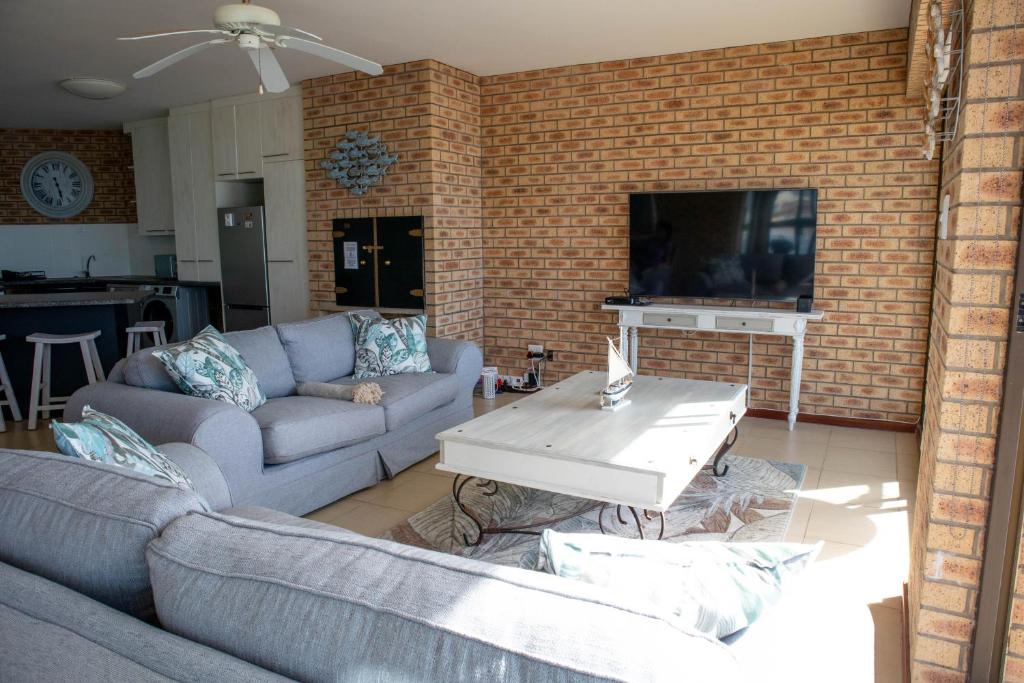 a living room with two couches and a tv at 7 Eagles View in Jeffreys Bay