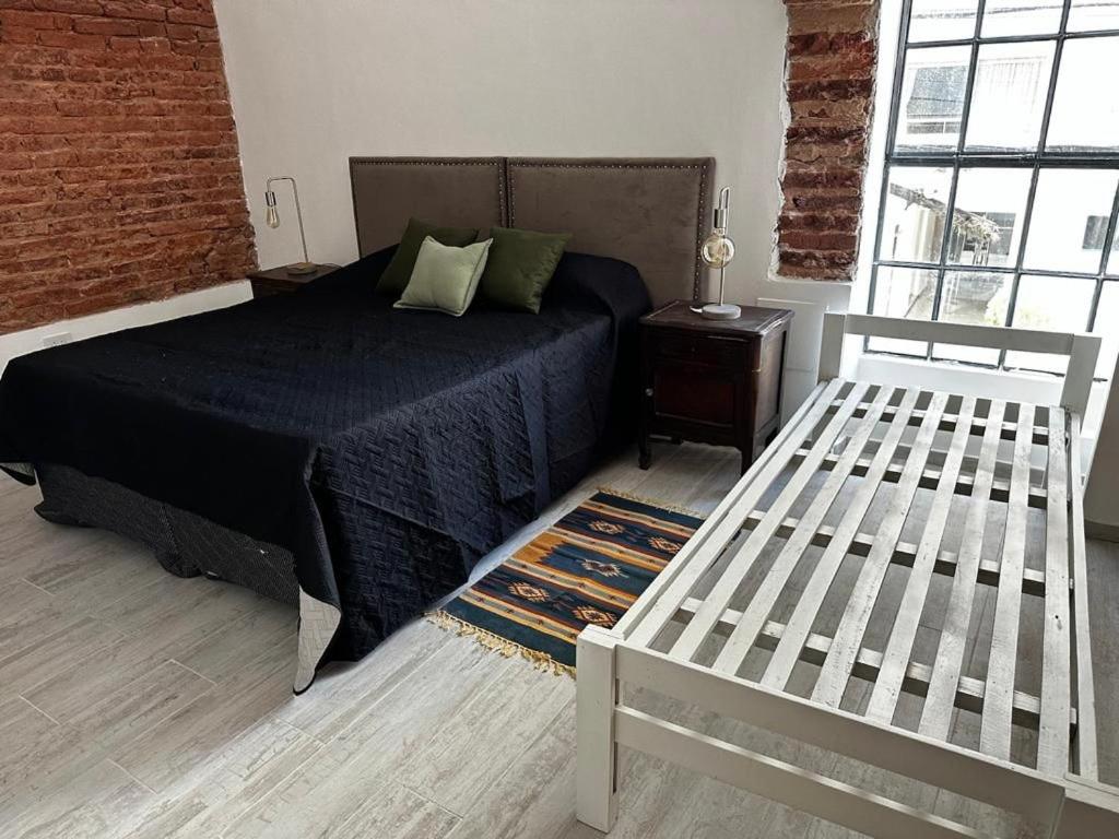 a bedroom with a bed and a chair and a brick wall at Pucara Apart - Habitaciones con baño privado in Corrientes