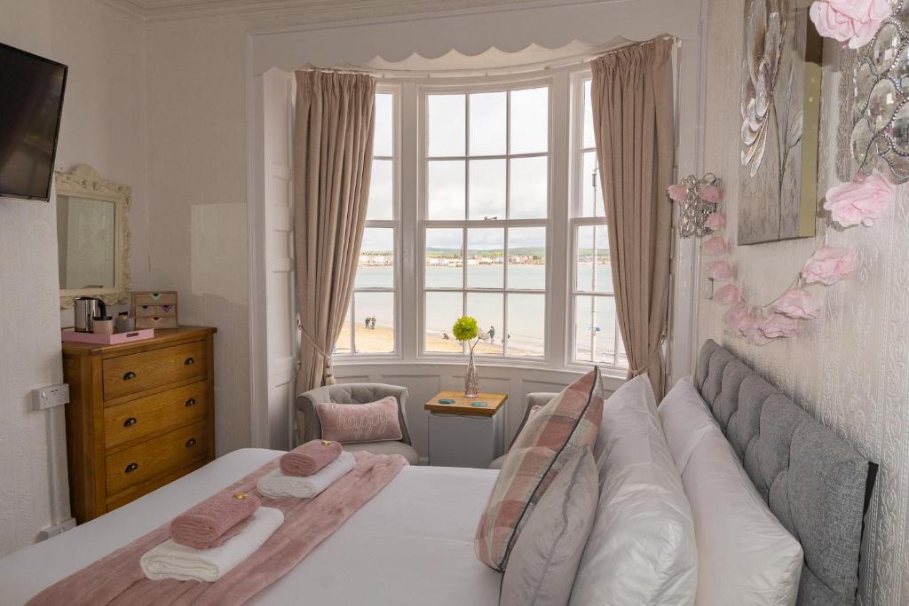 a bedroom with a bed and a large window at Seacrest Guest House in Weymouth