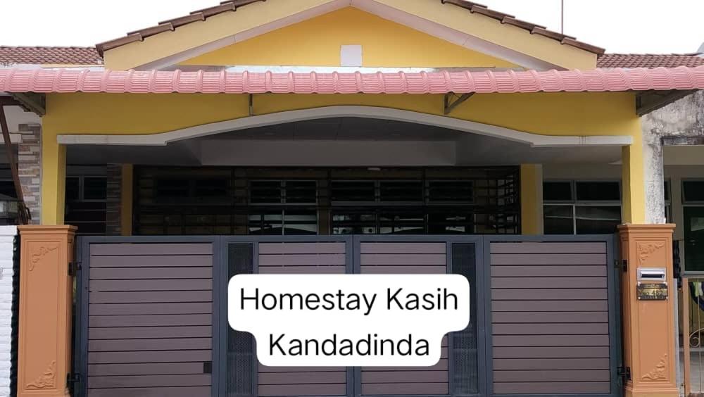 a house with a sign in front of a garage at Homestay Kasih KandAdinda in Kampung Gurun