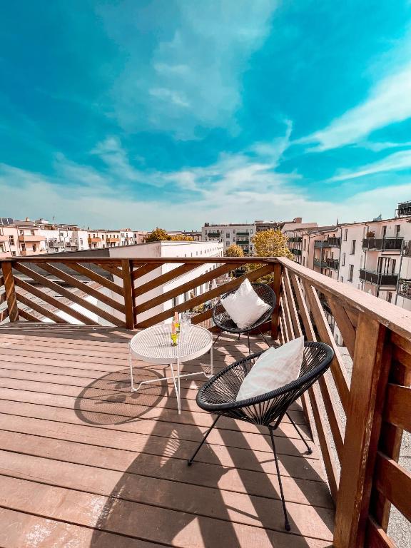 d'une terrasse avec 2 chaises et une table sur un balcon. dans l'établissement Rooftop Feeling erleben Sie Leipzig von oben, à Leipzig