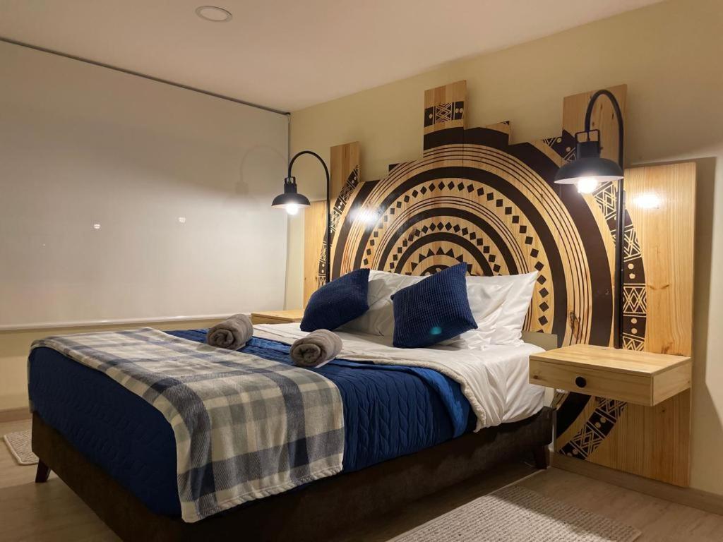 Schlafzimmer mit einem Bett mit einem großen Kopfteil in der Unterkunft Magnifico apartamento in Bogotá
