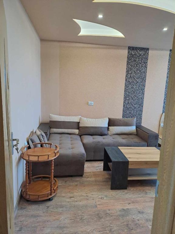 een woonkamer met een bank en een tafel bij Луксозен апартамент с гледка към парк и център in Yambol