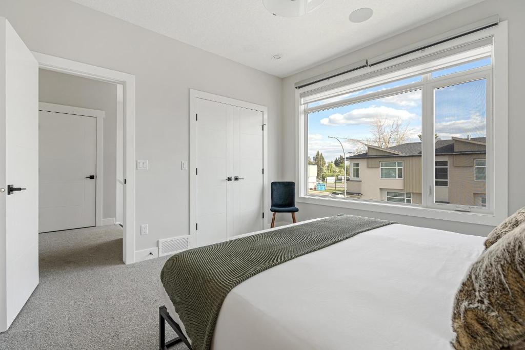 um quarto com uma cama e uma grande janela em Luxury Hillhurst Home Central Location 3 Br em Calgary