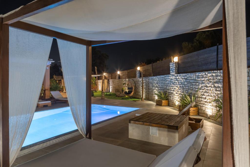 a view of a swimming pool from a house at night at Villa Bella Donna Corfu in Corfu
