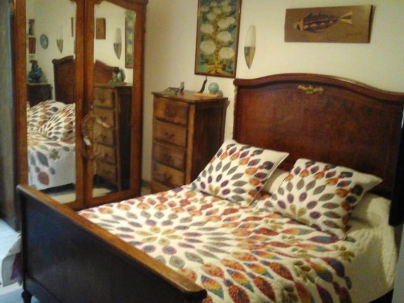 1 dormitorio con 1 cama con cabecero de madera y espejo en Mendiondo Gaü Eztia 