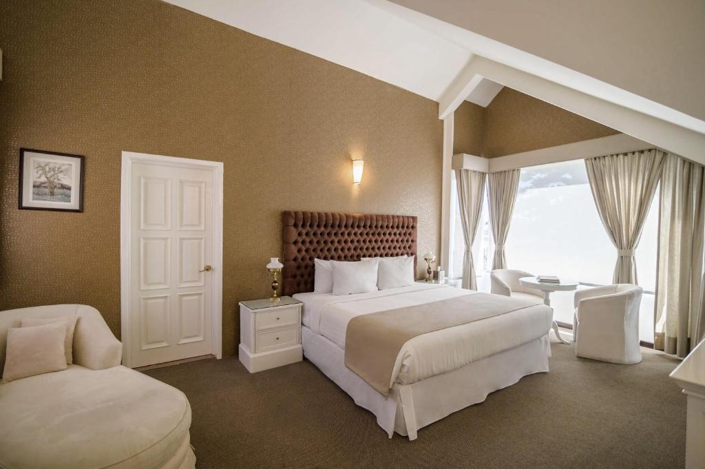 Un dormitorio con una cama grande y una ventana en Casa Bonita Hotel & Luxury Residence, en Oaxaca City