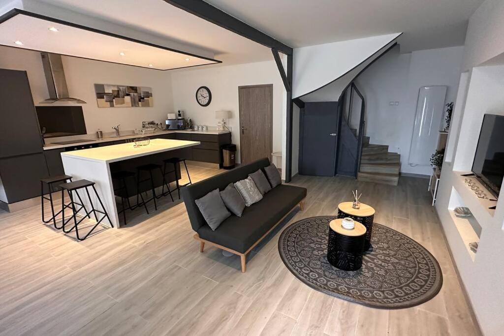 uma sala de estar e cozinha com um sofá e uma mesa em Maison entièrement rénovée em Ambarès-et-Lagrave