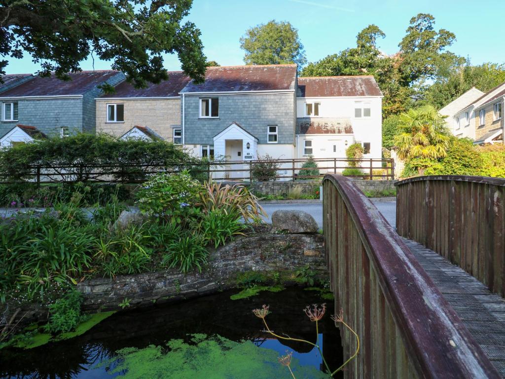 a bridge over a pond with houses in the background at Primrose Cottage in Falmouth