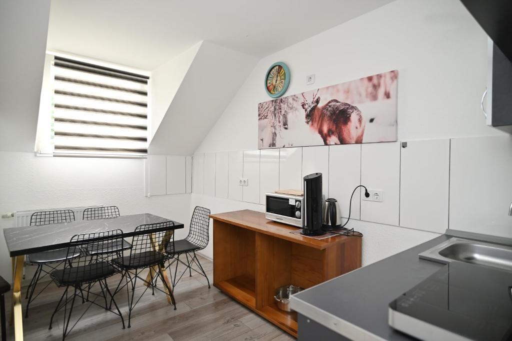eine Küche mit einem Tisch, Stühlen und einer Mikrowelle in der Unterkunft Ferienwohnung&Aparts By kispet group hotels in Oberhausen in Oberhausen