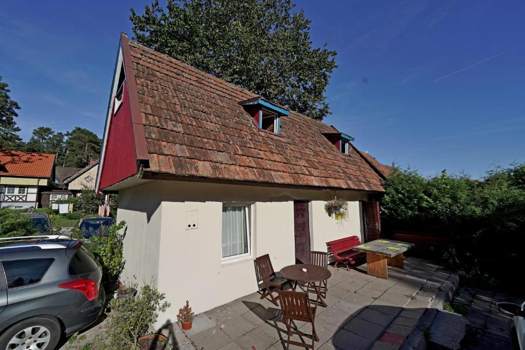a small white house with a table and chairs at Skruzdėlynas in Nida