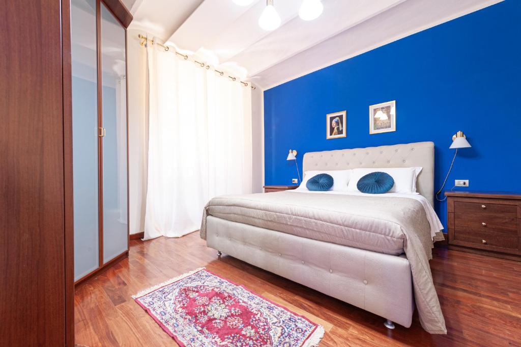 um quarto azul com uma cama e uma parede azul em Maison Indipendenza em Bolonha